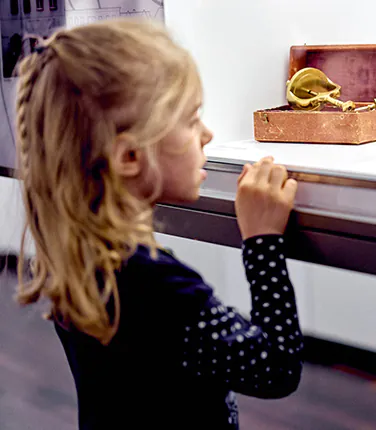 Mädchen schaut auf altes Werkzeug